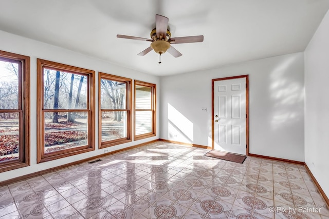 spare room with ceiling fan and a wealth of natural light