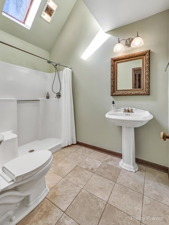 bathroom featuring toilet, lofted ceiling with skylight, tile patterned floors, and a shower with shower curtain