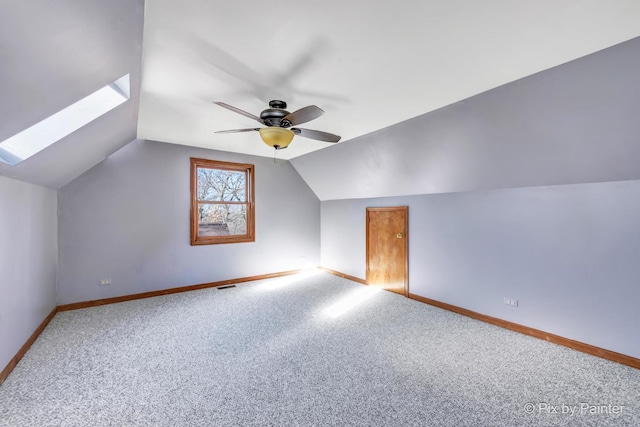 bonus room featuring lofted ceiling with skylight, ceiling fan, and carpet