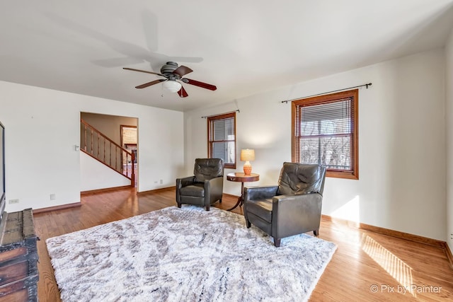 sitting room with ceiling fan and wood-type flooring