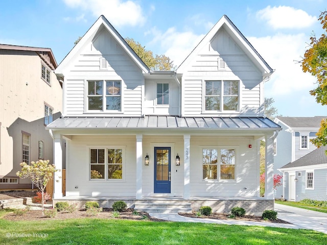 modern inspired farmhouse featuring a front yard and covered porch