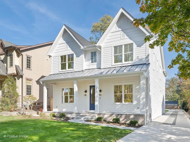 modern farmhouse style home with a front lawn and a porch