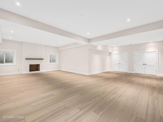 unfurnished living room featuring a fireplace and light hardwood / wood-style flooring