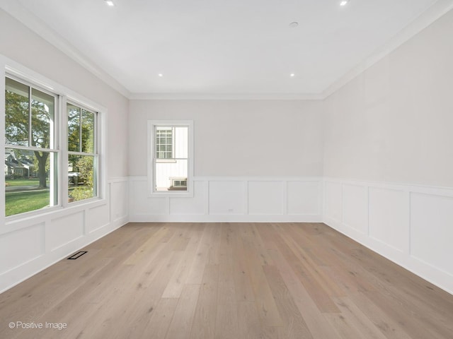 empty room featuring crown molding and light hardwood / wood-style flooring