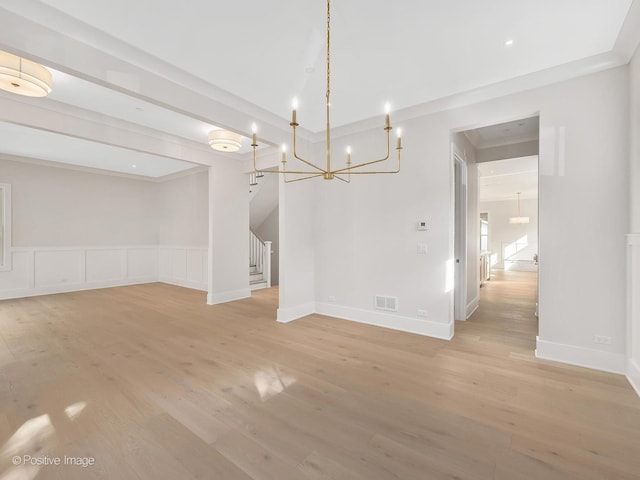 unfurnished dining area featuring crown molding and light hardwood / wood-style floors