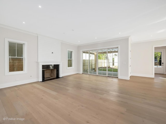 unfurnished living room featuring a high end fireplace, ornamental molding, and light hardwood / wood-style floors