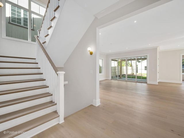 stairway featuring hardwood / wood-style floors and ornamental molding