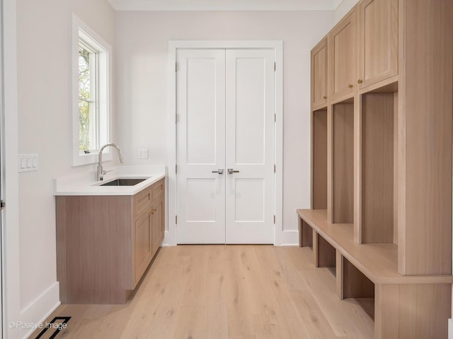 mudroom featuring sink and light hardwood / wood-style flooring