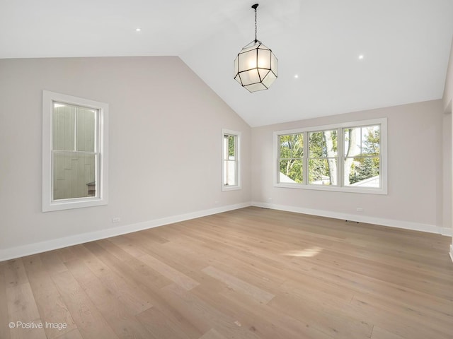 unfurnished room featuring lofted ceiling and light wood-type flooring