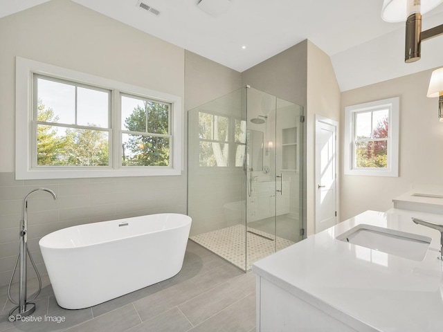 bathroom with vanity, separate shower and tub, tile walls, and tile patterned floors