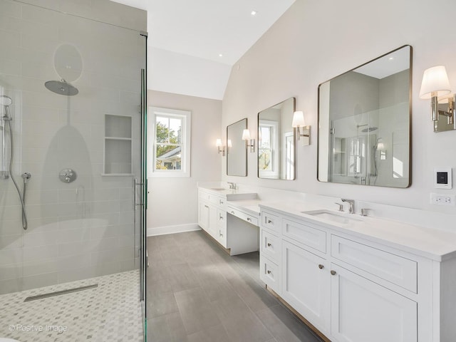 bathroom with vanity, vaulted ceiling, and a tile shower