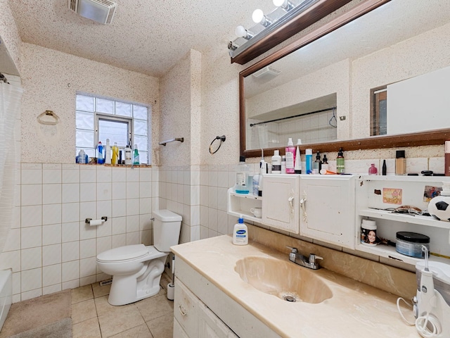 bathroom featuring toilet, tile walls, vanity, curtained shower, and tile patterned flooring