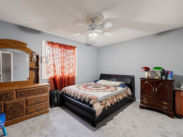 carpeted bedroom featuring a textured ceiling and ceiling fan