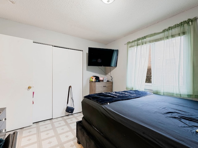 bedroom featuring a textured ceiling and a closet