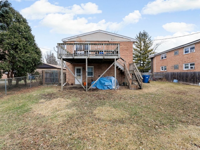 back of property with a wooden deck and a lawn