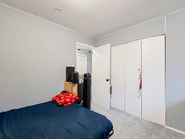 bedroom featuring a closet, light carpet, and a textured ceiling