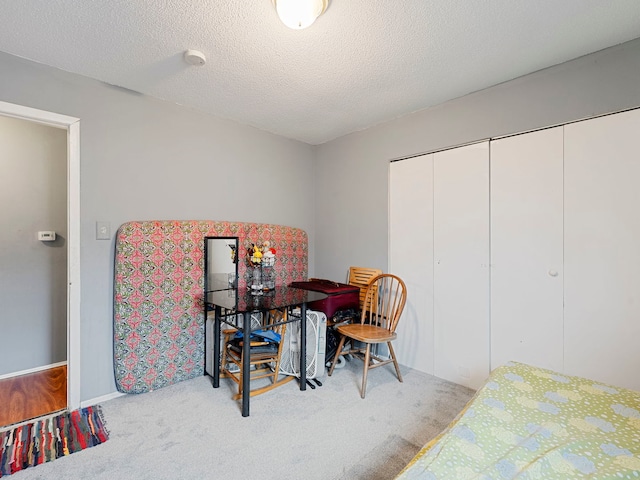 bedroom featuring a closet, a textured ceiling, and carpet