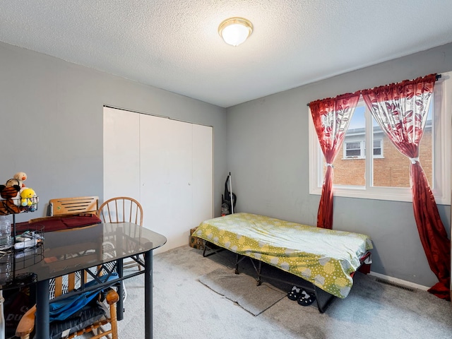 bedroom featuring carpet, a textured ceiling, and a closet