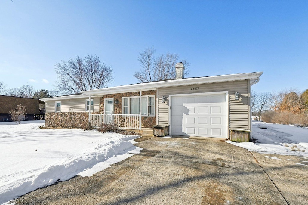 single story home featuring a garage and a porch