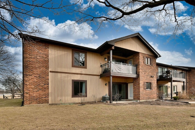 back of house with a balcony, a yard, and central AC