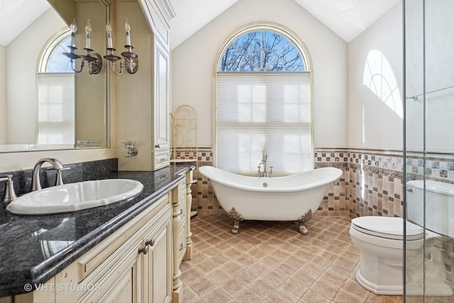 bathroom featuring a soaking tub, toilet, tile walls, and plenty of natural light