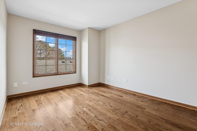 empty room with light wood-style flooring and baseboards