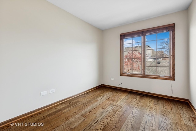 unfurnished room with visible vents, baseboards, and wood finished floors