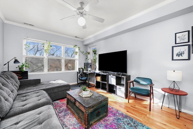 living room with crown molding, wood-type flooring, and ceiling fan