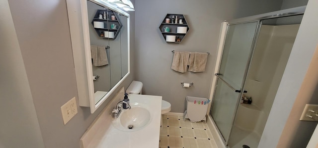 bathroom featuring tile patterned flooring, toilet, sink, and a shower with shower door