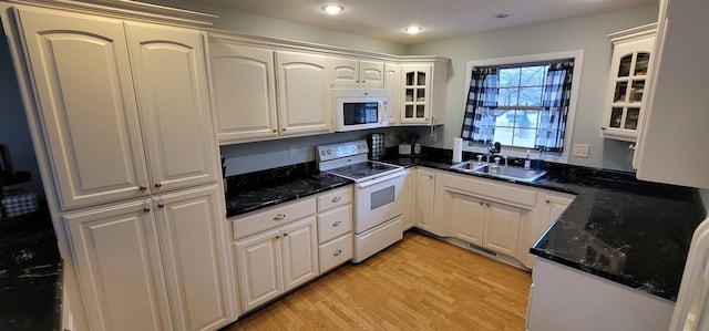 kitchen with sink, white cabinets, and white appliances