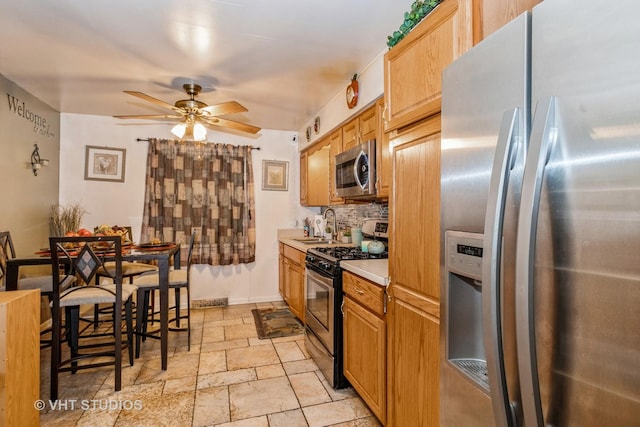 kitchen featuring tasteful backsplash, sink, stainless steel appliances, and ceiling fan