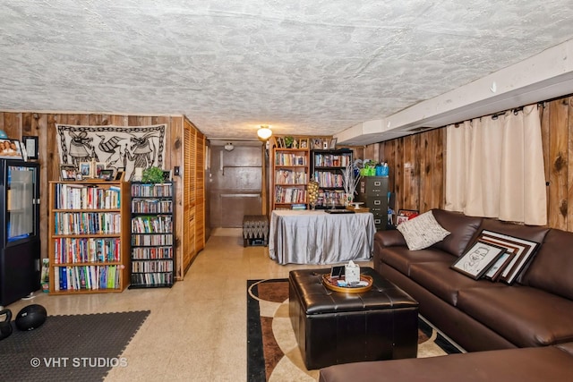 living room featuring a textured ceiling and wood walls