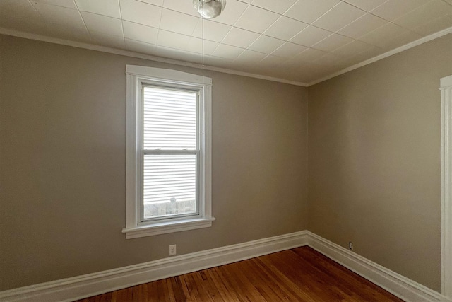 spare room with hardwood / wood-style floors and crown molding