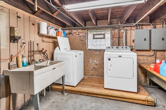 laundry room with sink, electric panel, and washer and clothes dryer