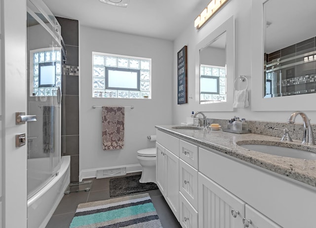 full bathroom featuring bath / shower combo with glass door, tile patterned flooring, plenty of natural light, and toilet