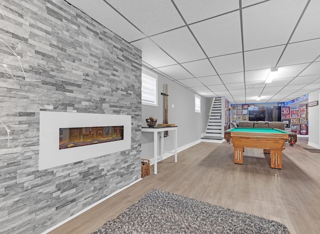 playroom with a paneled ceiling, a large fireplace, hardwood / wood-style floors, and pool table