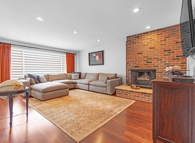 living room featuring hardwood / wood-style floors and a brick fireplace