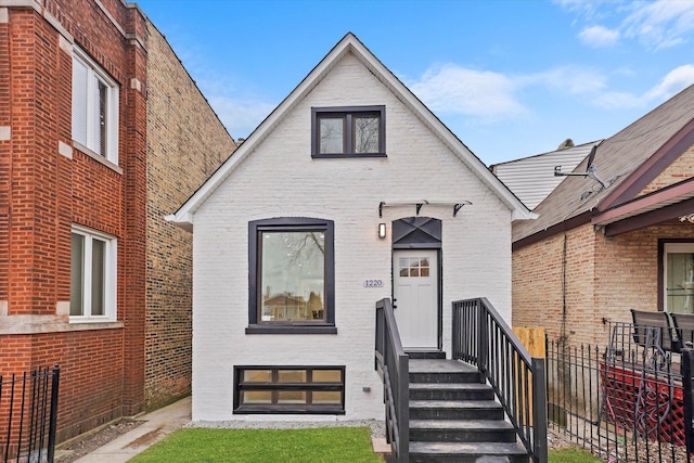 view of front of house with brick siding and fence