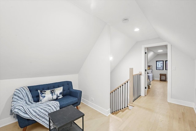 sitting room featuring baseboards, lofted ceiling, wood finished floors, an upstairs landing, and recessed lighting