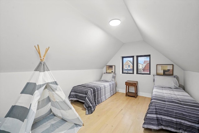 bedroom with lofted ceiling, wood finished floors, and baseboards