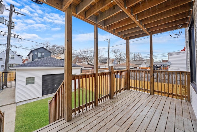 wooden terrace with a garage, a residential view, an outdoor structure, and a lawn