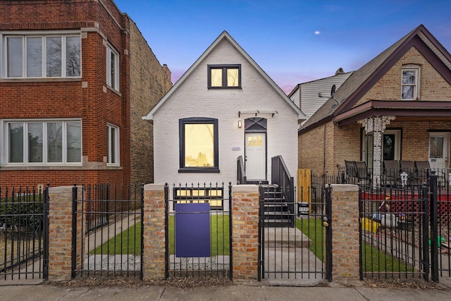 view of front of home with a fenced front yard, a gate, and brick siding