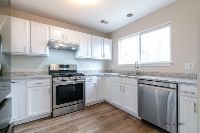 kitchen with sink, gas range, light wood-type flooring, dishwashing machine, and white cabinets