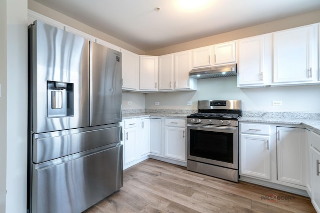 kitchen with light stone countertops, white cabinetry, and appliances with stainless steel finishes