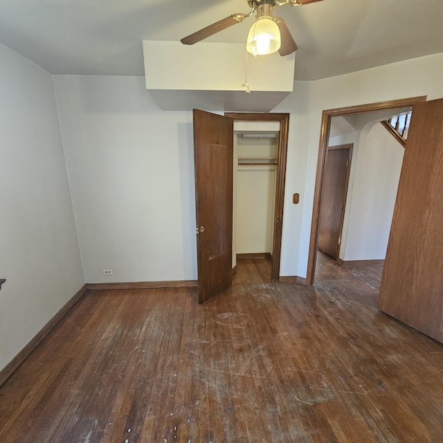 unfurnished bedroom with dark wood-type flooring, a closet, and ceiling fan