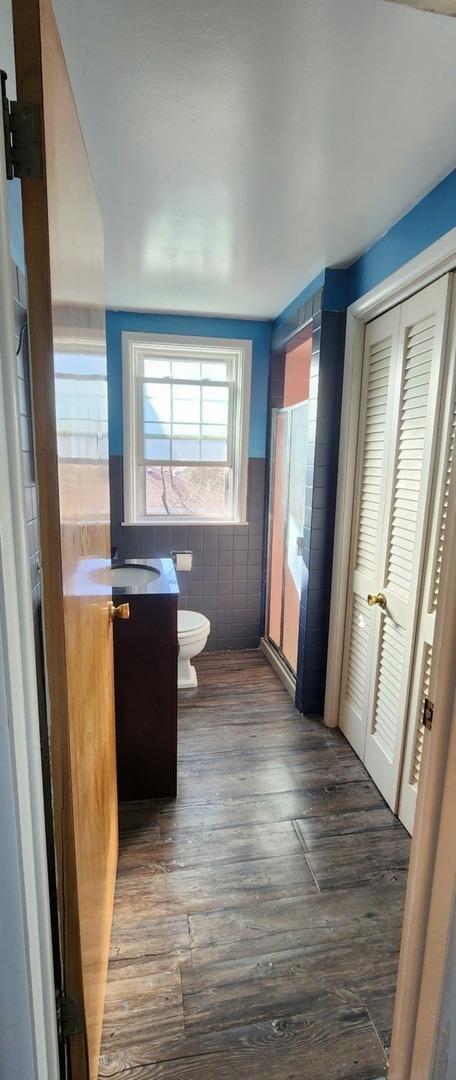 bathroom with vanity, hardwood / wood-style floors, tile walls, and toilet