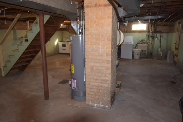 basement featuring water heater, sink, and washer / clothes dryer