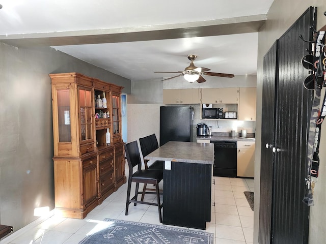 kitchen featuring light tile patterned floors, a breakfast bar area, ceiling fan, black appliances, and a kitchen island