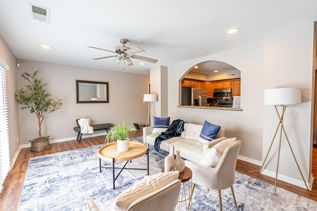 living room featuring ceiling fan and light wood-type flooring