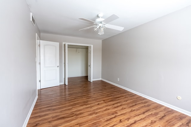 unfurnished bedroom featuring hardwood / wood-style flooring, ceiling fan, and a closet